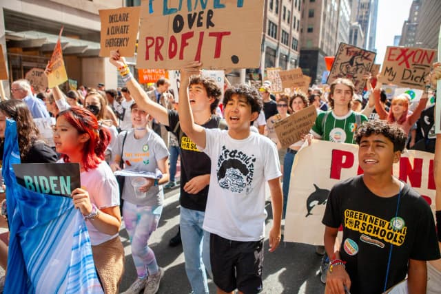 Students marching with signs demanding divestment from fossil fuels.