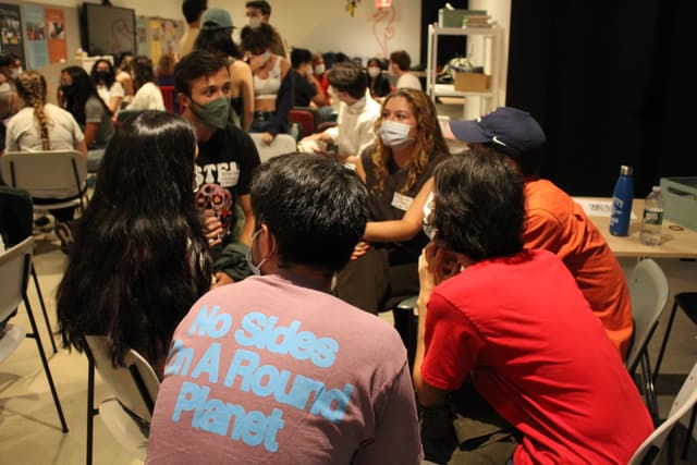 Students gathered in a circle discussion at an organizing summit.