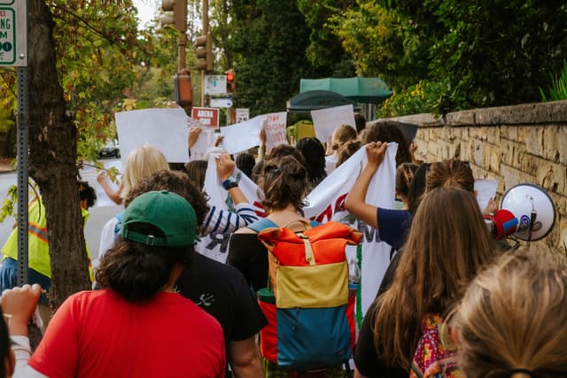 Student organizers gathered outside a university building calling for climate action.